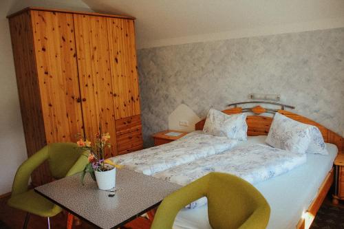 a bedroom with a bed and a table with chairs at Haus Rupitsch in Winklern
