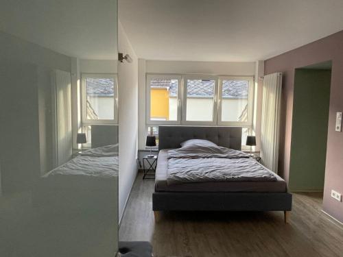 1 dormitorio con 1 cama y 2 ventanas en le cadeau, en Wincheringen