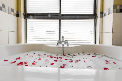 a bath tub with roses on it with a sink at Hotel Rio in Nairobi