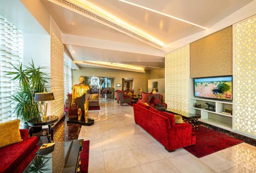 a lobby with red furniture and a flat screen tv at Swiss-Belhotel Seef Bahrain in Manama