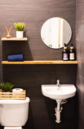a bathroom with a sink and a mirror at Habitación Agua - Villa Valle Campo in Nahuizalco