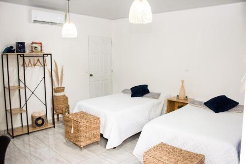 two beds in a room with white walls at Habitación Agua - Villa Valle Campo 