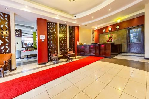 a lobby with a red carpet and a red rug at Hotel Rio in Nairobi