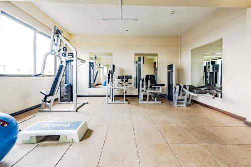 a gym with treadmills and machines in a room at Hotel Rio in Nairobi