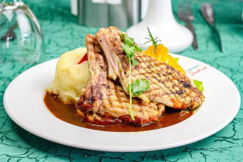 a plate of meat and mashed potatoes on a table at Hotel Rio in Nairobi