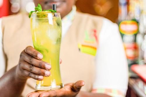 a man holding a drink with a lime and mint at Hotel Rio in Nairobi