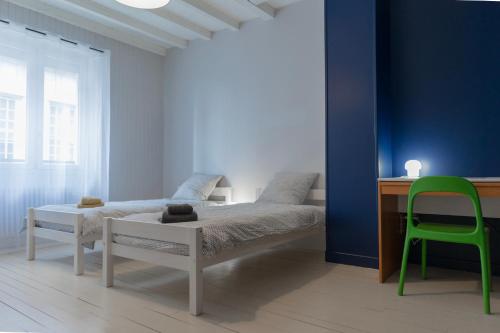 Orgelet的住宿－L'Orgelétaine : Grande Maison au milieu des Lacs du Jura，一间卧室配有一张床、一张桌子和一把绿色椅子