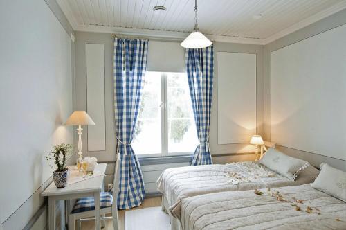 a bedroom with two beds and a window at Westerby Gård in Inkoo