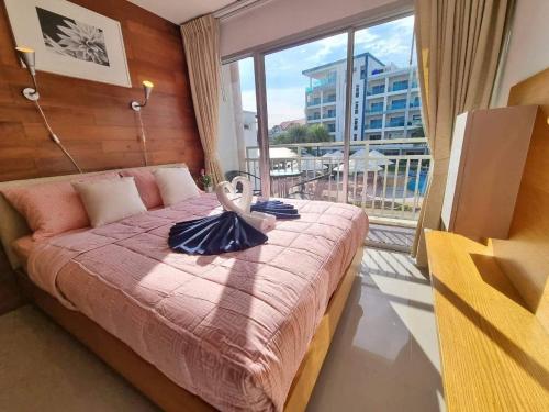 a bedroom with a bed with a large window at Grandbeach1 Condo A203 in Ban Tha Fat