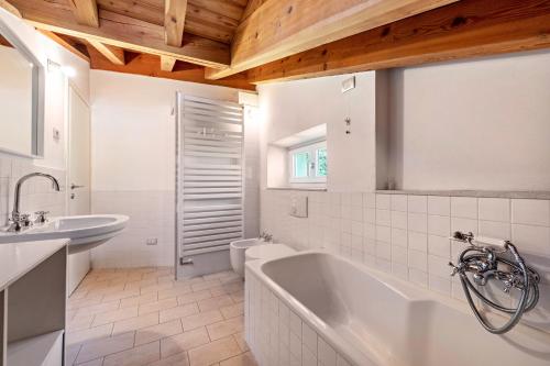 ein Badezimmer mit einer Badewanne, einem Waschbecken und einem WC in der Unterkunft Appartamento molini in casa Daria in Gargnano