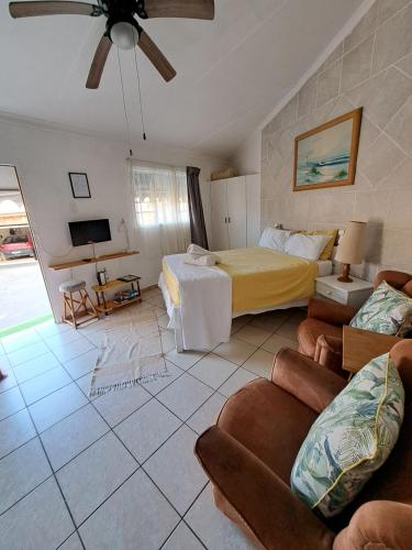 a bedroom with a bed and a couch and a tv at 38 Park Avenue, Desainger, Tongaat in Densainagar