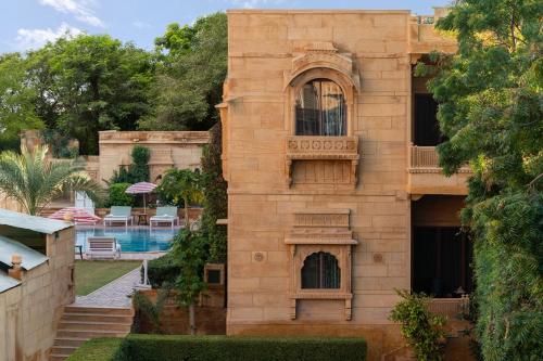 a building with a balcony and a swimming pool at WelcomHeritage Mandir Palace in Jaisalmer