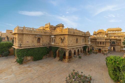 a large stone building with ivy on a courtyard at WelcomHeritage Mandir Palace in Jaisalmer