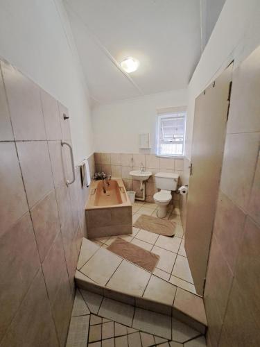 łazienka z wanną, toaletą i umywalką w obiekcie 38 Park Avenue, Desainger, Tongaat w mieście Densainagar