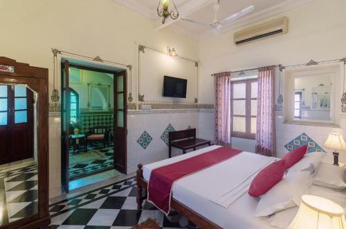 a bedroom with a bed and a tv in it at WelcomHeritage Mandir Palace in Jaisalmer