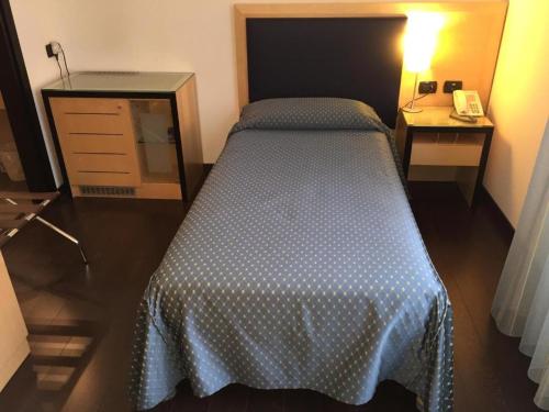 um quarto com uma cama, um telefone e uma cómoda em Luxury Rooms Padova Station em Pádua