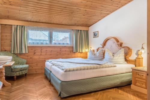 1 dormitorio con 1 cama grande y 1 silla en Villa Soldanella en Ortisei