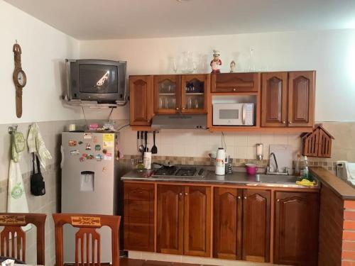 a kitchen with wooden cabinets and a white refrigerator at San Gil beautiful house in San Gil