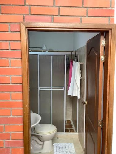 a bathroom with a toilet in a brick wall at San Gil beautiful house in San Gil
