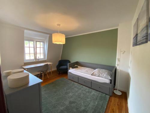 a bedroom with a bed and a desk and a chair at Apt5 - Ferienwohnung Brötzingen im 4 OG in Pforzheim