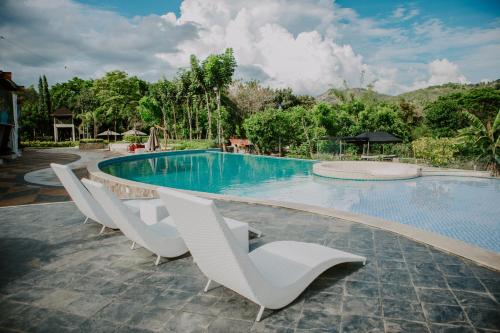 a swimming pool with white chairs around it at Estancia de lorenzo in San Mateo