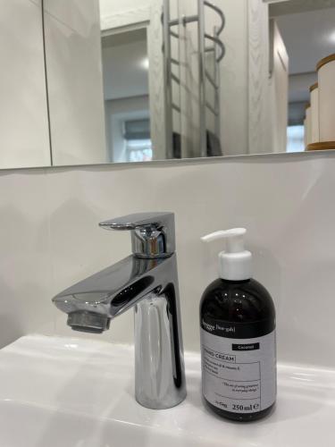 a bottle of soap sitting next to a bathroom sink at Oldtown apartment in Vilnius