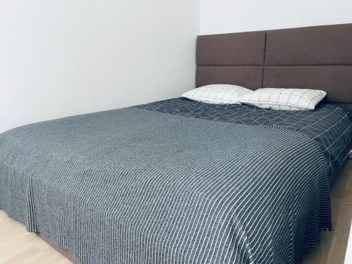 a bed with a blue blanket and two pillows at Oldtown apartment in Vilnius