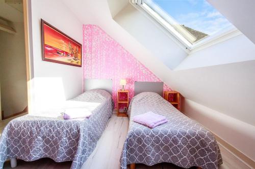 a attic room with two beds and a window at cavalibre-mesquer in Mesquer