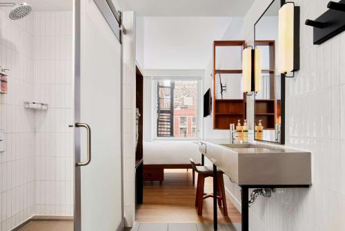 La salle de bains est pourvue d'un lavabo et d'un miroir. dans l'établissement Arlo NoMad, à New York