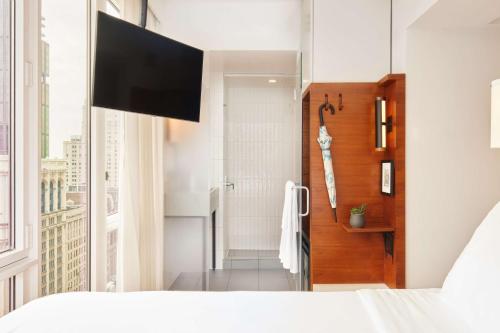 a bedroom with a bed and a bathroom with a shower at Arlo NoMad in New York