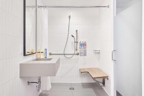 a white bathroom with a sink and a shower at Arlo NoMad in New York
