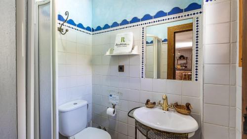 y baño con aseo, lavabo y espejo. en Casa Rural La Rubia Nigüelas by Ruralidays, en Nigüelas