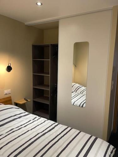 une chambre avec un lit et un miroir dans l'établissement Magnifique appartement T3 tout confort, à Perpignan