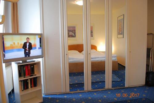 a bedroom with a bed and a tv in a mirror at Miramar-App-08 in Ahlbeck