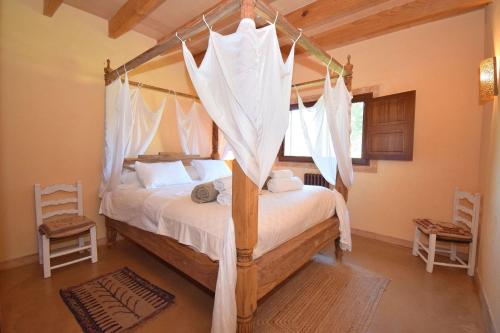 sypialnia z łóżkiem z baldachimem i białymi zasłonami w obiekcie 019 Villa Nuria ET2369 by Mallorca Charme w mieście Muro