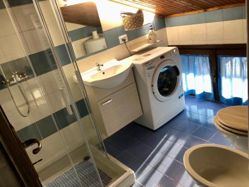 uma casa de banho com uma máquina de lavar roupa e um lavatório em Appartamento “Del TuF” in Sondrio Centro em Sondrio