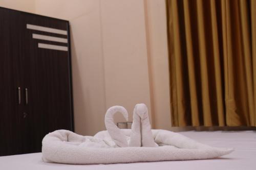 a towel animal shaped like swans sitting on a bed at Hotel Saan Berhampore in Baharampur