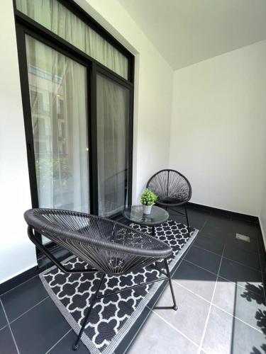 a balcony with a bench and a table and a window at Embassy Gardens Luxury Apartments in Accra