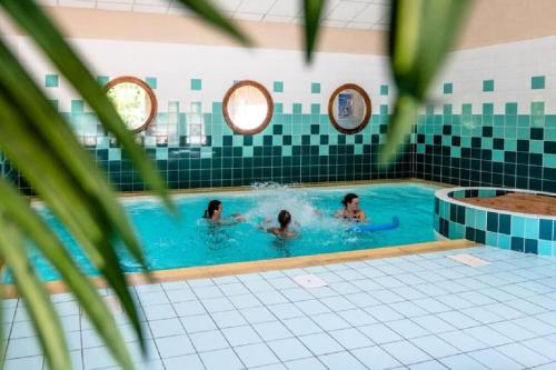 un groupe de personnes dans une piscine dans l'établissement Appartement cosy T3 4 à 6 pers avec Piscines Intérieure, Extérieure & Sauna à Samoëns en Haute-Savoie, à Samoëns