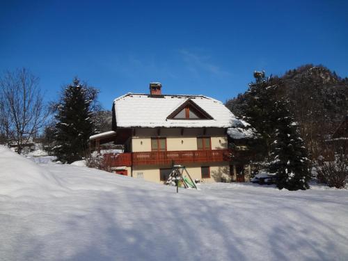 una casa con techo cubierto de nieve en la nieve en Apartments Valant en Bled