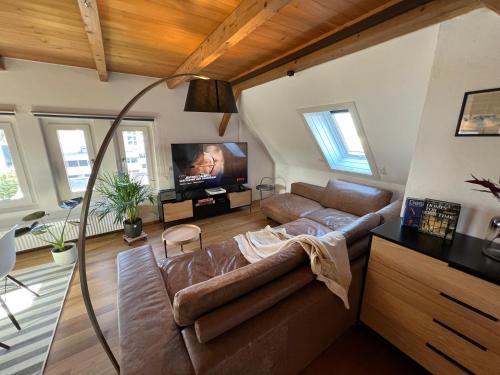 a living room with a couch and a flat screen tv at Wohlfühl Loft - Seenähe, Netflix, Boxspringbett, Küche in Bregenz