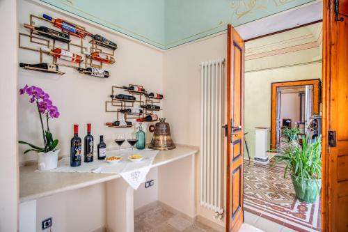 Zimmer mit einem Tisch und Weinflaschen in der Unterkunft Palazzo Stunis - Dimora di Charme in Ostuni