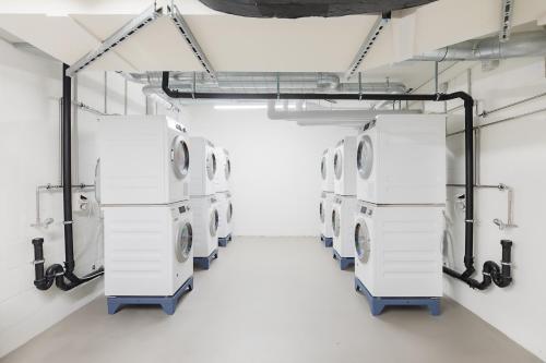 a row of white washing machines in a room at VISIONAPARTMENTS Basel - contactless check-in in Basel