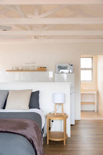 ein Schlafzimmer mit zwei Betten und einem Tisch mit Lampe in der Unterkunft Nornalup Riverside Chalets in Nornalup