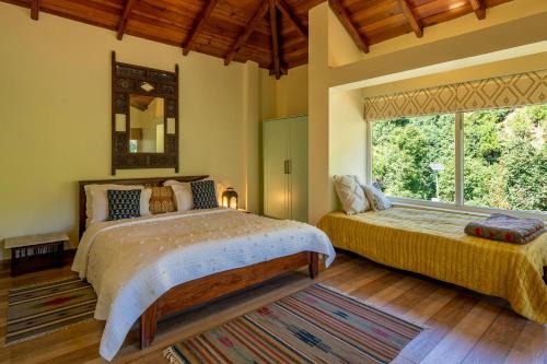une chambre avec deux lits et une grande fenêtre dans l'établissement Hollyhock Cottage by VEO - Part of StayVista, à Rāmgarh