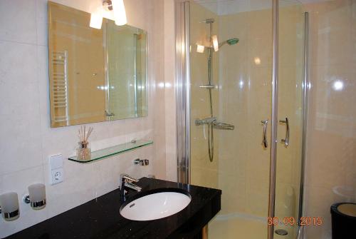 ヘリングスドルフにあるSan-Marino-App-04のバスルーム(洗面台、ガラスドア付きのシャワー付)