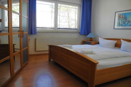 Schlafzimmer mit einem großen Bett und blauen Vorhängen in der Unterkunft Strandoase Whg 14 in Heringsdorf