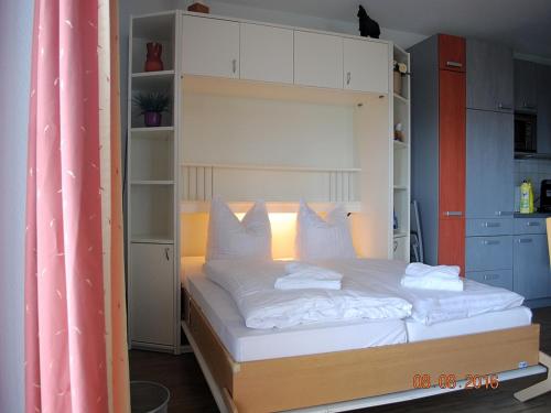 a bedroom with a bunk bed with white sheets and pillows at Strandoase-App-04 in Heringsdorf