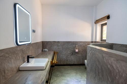 a bathroom with a sink and a mirror at Swisscocobeach in Nosy Be