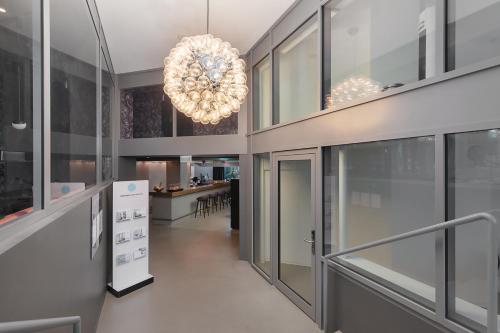 un couloir avec un lustre dans un bâtiment dans l'établissement VISIONAPARTMENTS Basel Nauenstrasse - contactless check-in, à Bâle